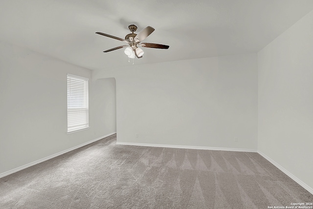 empty room featuring ceiling fan and carpet