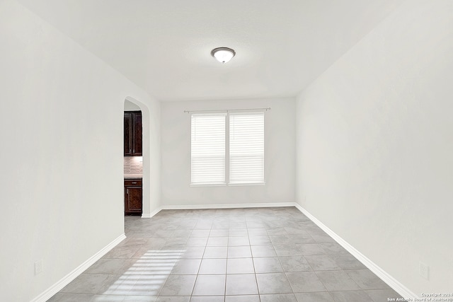 unfurnished room with light tile patterned flooring