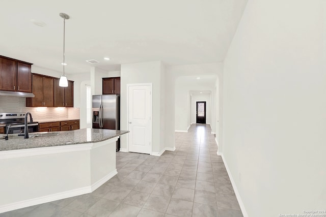 kitchen featuring tasteful backsplash, light tile patterned flooring, stainless steel appliances, and pendant lighting