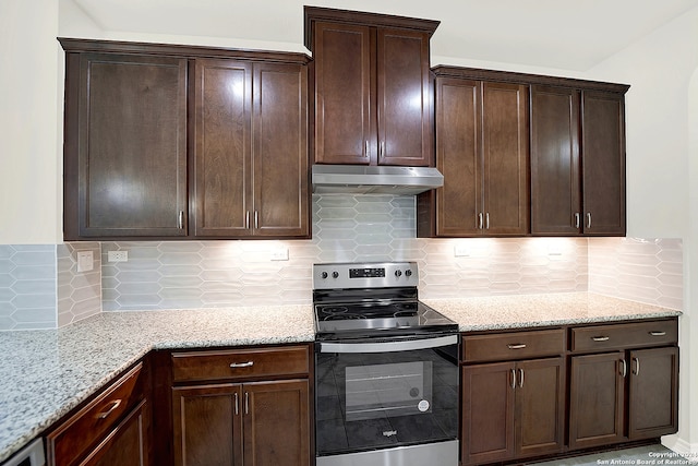 kitchen with dark brown cabinets, electric range, tasteful backsplash, and light stone counters