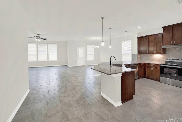 kitchen with pendant lighting, dark stone counters, stainless steel appliances, kitchen peninsula, and decorative backsplash