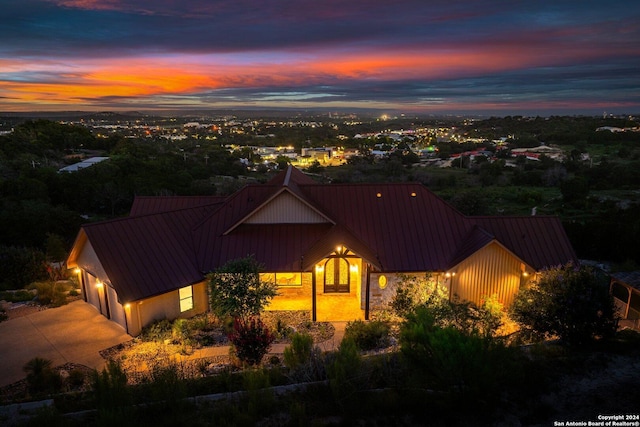 view of front facade featuring an attached garage, a standing seam roof, metal roof, and concrete driveway