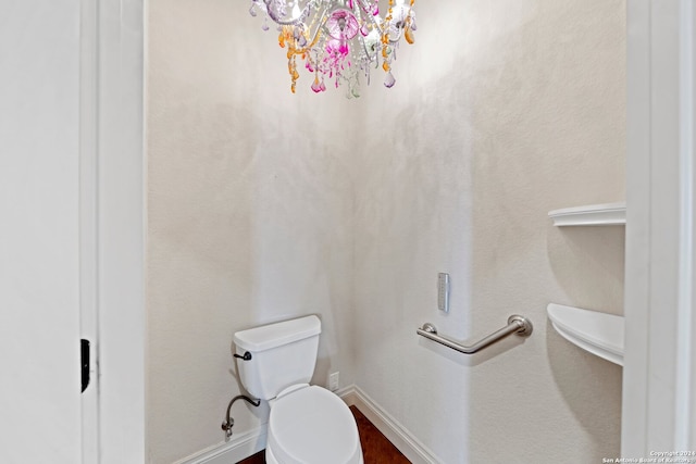 bathroom with a notable chandelier and toilet