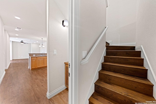 staircase with baseboards, visible vents, a ceiling fan, wood finished floors, and recessed lighting