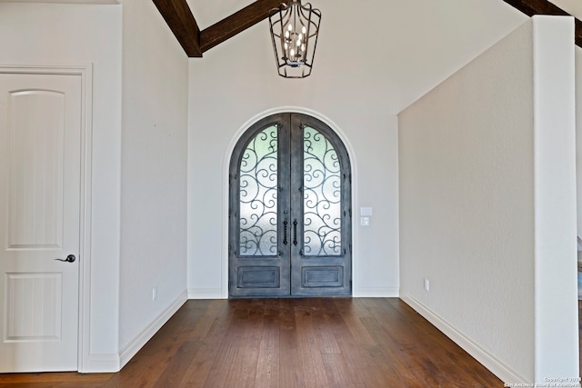 entrance foyer featuring french doors, lofted ceiling with beams, and dark hardwood / wood-style floors