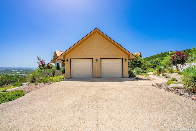 view of front of house featuring a garage, metal roof, and stucco siding