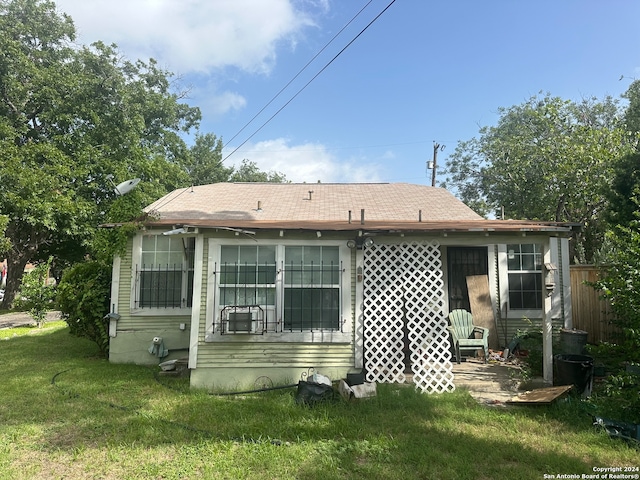 rear view of property with a lawn