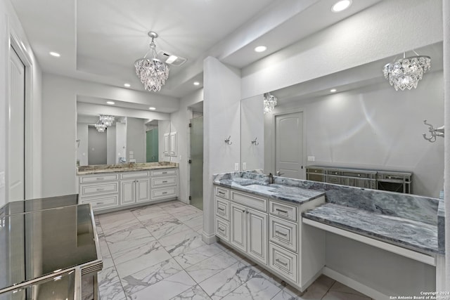 bathroom with tile patterned floors, a raised ceiling, a chandelier, and double vanity