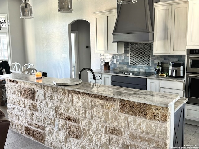 kitchen featuring custom exhaust hood, light stone countertops, sink, and black electric stovetop