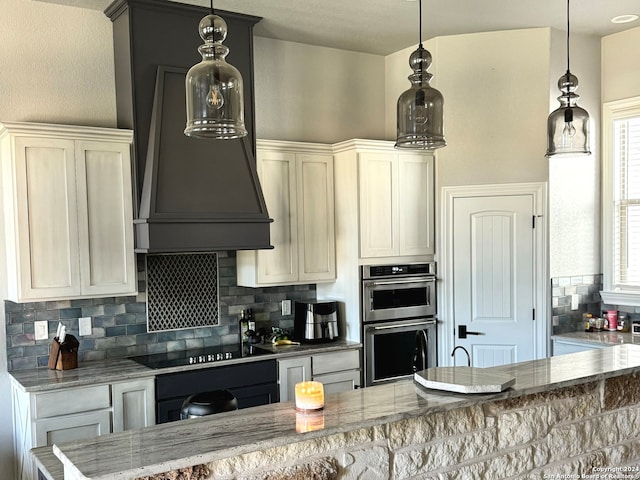 kitchen featuring double oven, light stone countertops, and hanging light fixtures