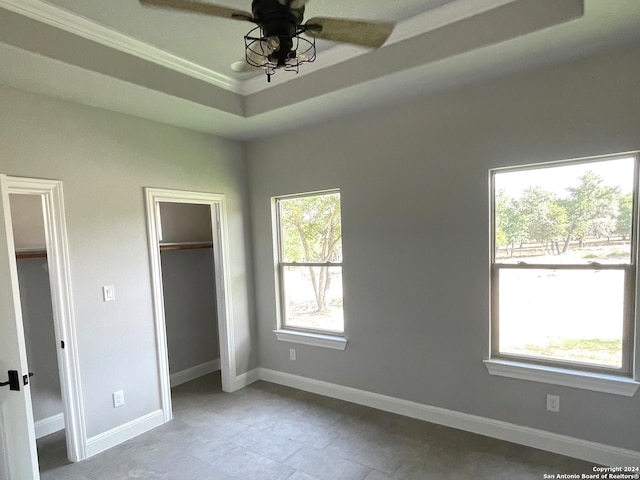 unfurnished bedroom with a raised ceiling, crown molding, and ceiling fan