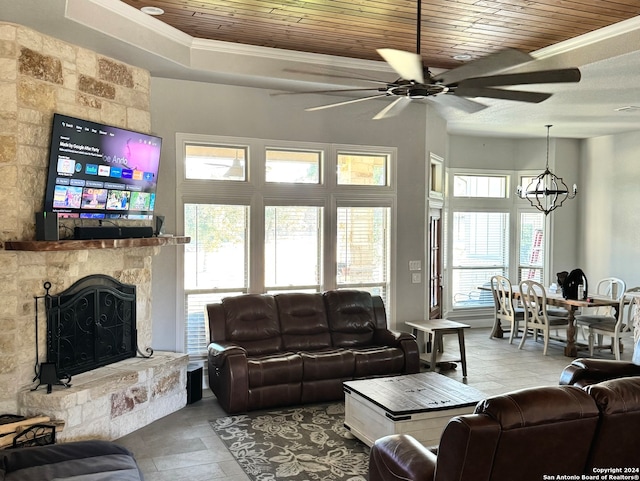 living room featuring ceiling fan with notable chandelier, a fireplace, ornamental molding, and wood ceiling