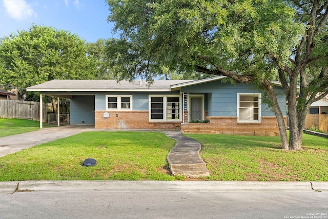 ranch-style house with brick siding, fence, driveway, and a front lawn