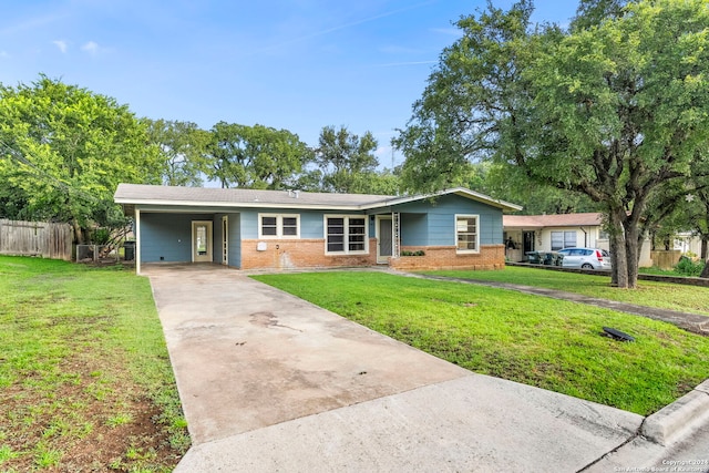 single story home featuring brick siding, a front yard, fence, a carport, and driveway