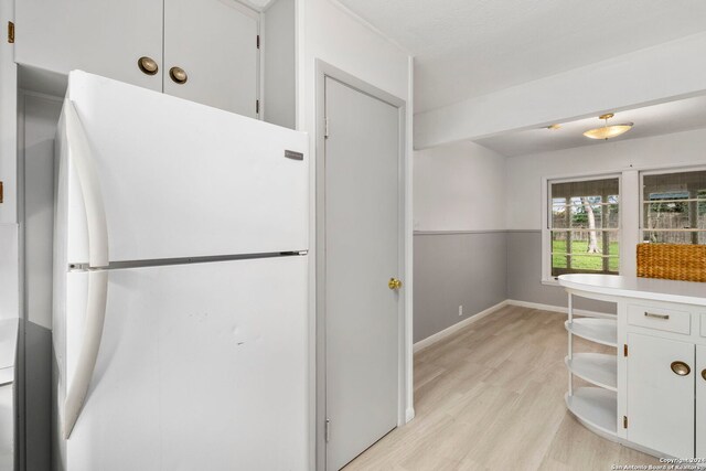 kitchen featuring white refrigerator, white cabinets, and light hardwood / wood-style floors