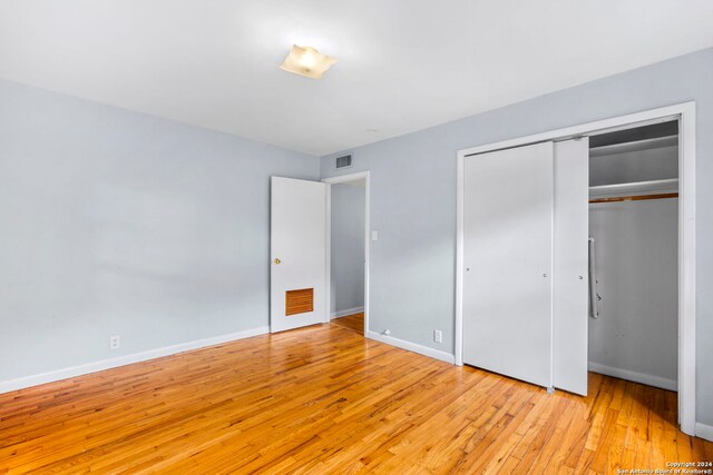 unfurnished bedroom featuring light hardwood / wood-style flooring and a closet