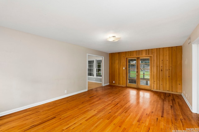 spare room featuring wooden walls and hardwood / wood-style floors