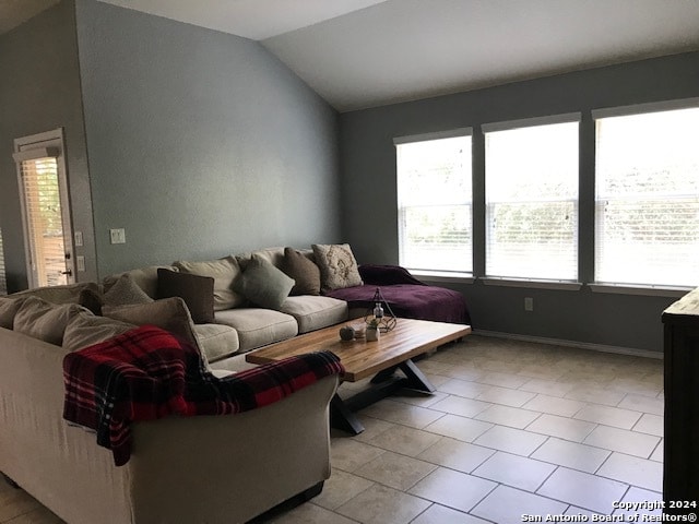 living room with light tile patterned floors and vaulted ceiling