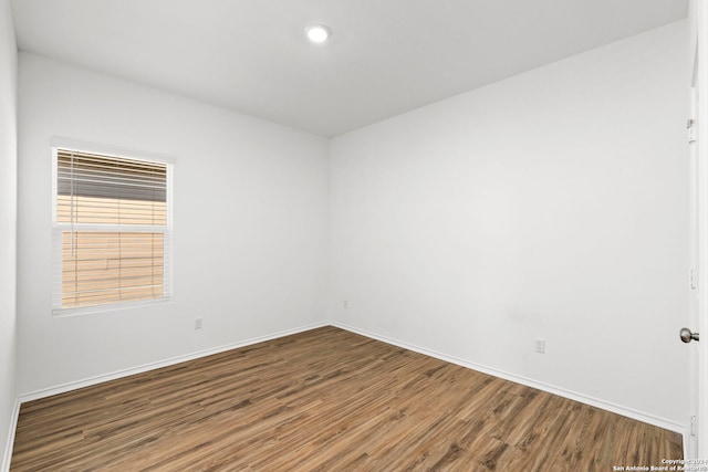 empty room featuring wood finished floors and baseboards