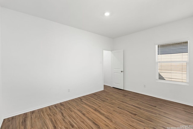 unfurnished room with dark wood-type flooring and baseboards