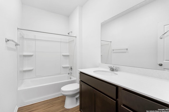 full bathroom with toilet, washtub / shower combination, wood finished floors, and vanity