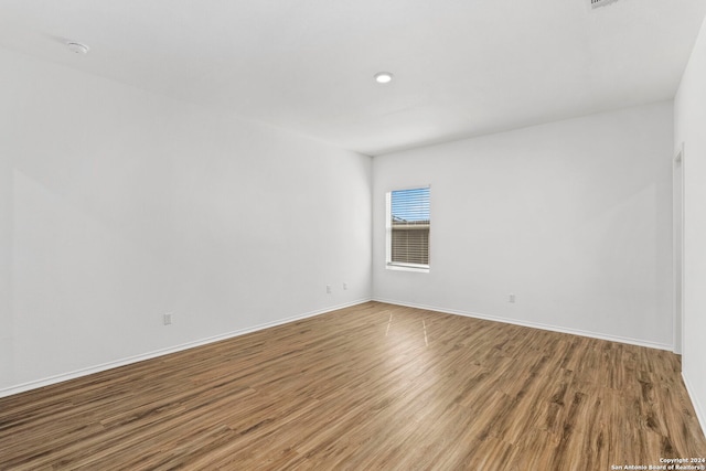 unfurnished room with baseboards and wood finished floors