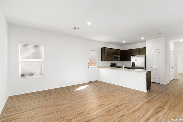 kitchen with light wood-type flooring, dark brown cabinetry, visible vents, and stainless steel appliances