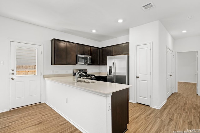 kitchen with appliances with stainless steel finishes, light countertops, and light wood finished floors