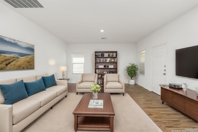 living room with light wood-type flooring, visible vents, and recessed lighting