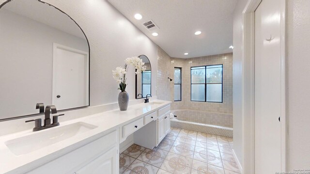 bathroom featuring independent shower and bath, vanity, and tile patterned floors