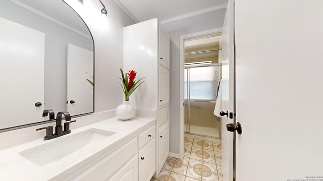 bathroom with vanity, a shower with shower door, crown molding, and tile patterned floors