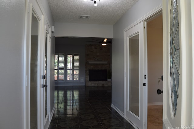 hallway with dark tile patterned floors and a textured ceiling