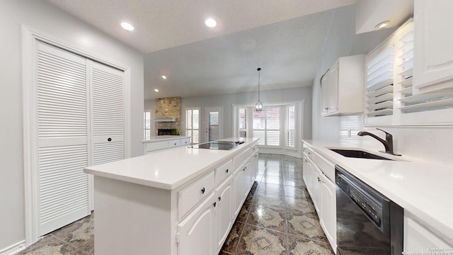 kitchen with white cabinets, a kitchen island, black appliances, decorative light fixtures, and sink