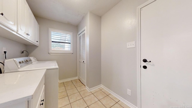 washroom featuring separate washer and dryer, cabinets, and light tile patterned floors