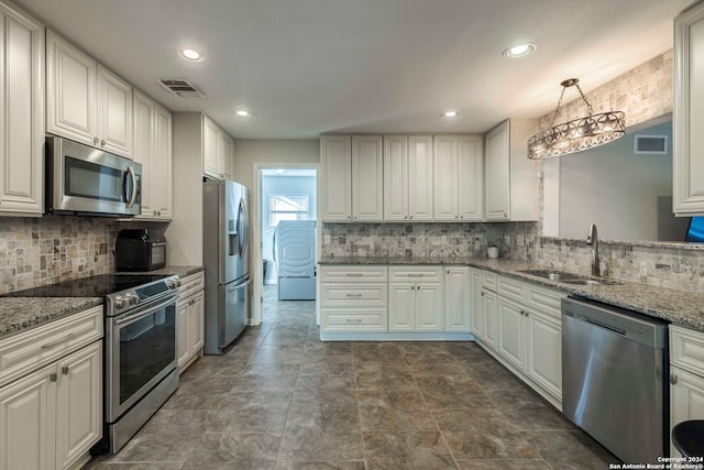 kitchen with stone counters, white cabinetry, tasteful backsplash, stainless steel appliances, and sink