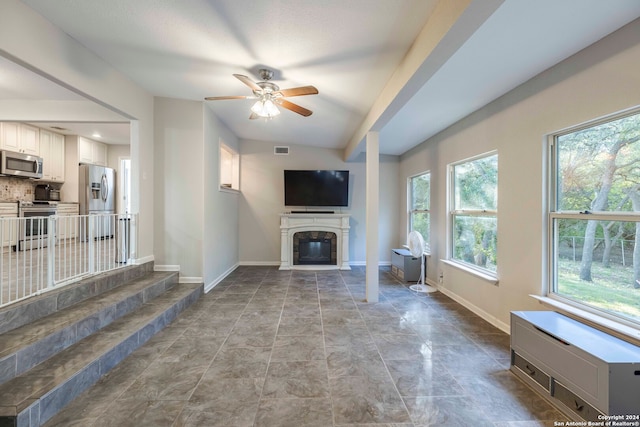 unfurnished living room with a fireplace, ceiling fan, and tile patterned flooring