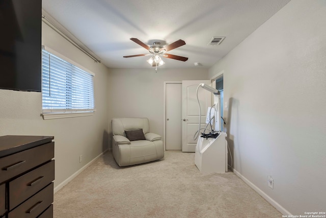 sitting room with ceiling fan and light carpet