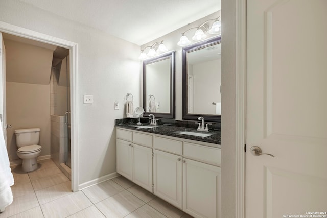 bathroom with a shower with door, toilet, dual vanity, and tile patterned floors