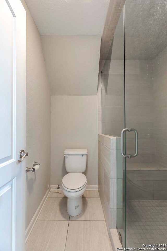 bathroom with an enclosed shower, toilet, and tile patterned floors