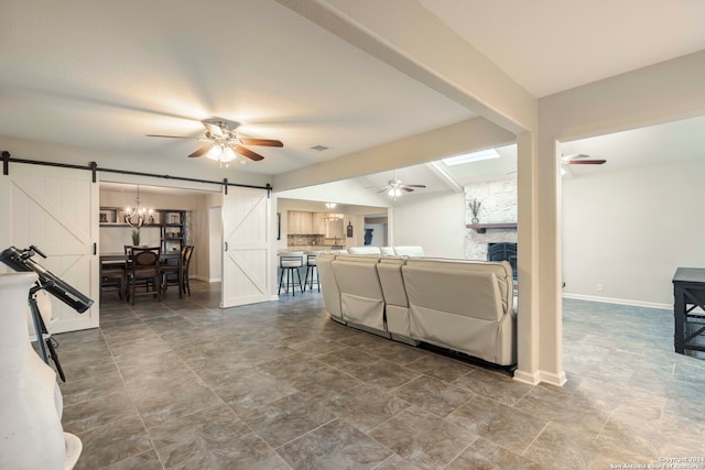 living room with a barn door, ceiling fan, beam ceiling, and tile patterned floors