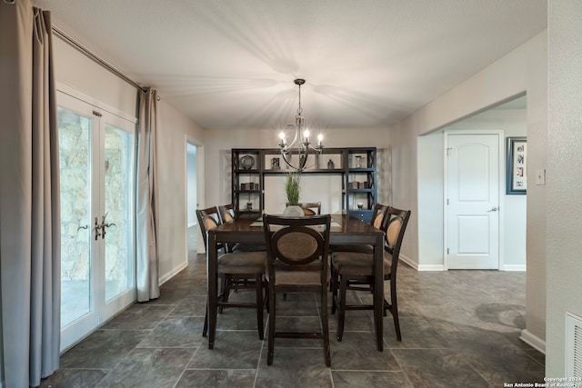 dining room with french doors, a chandelier, and dark tile patterned floors