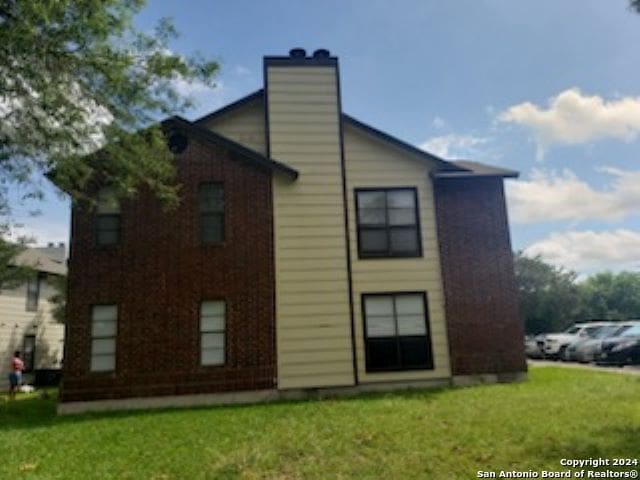 rear view of property with a yard and a chimney