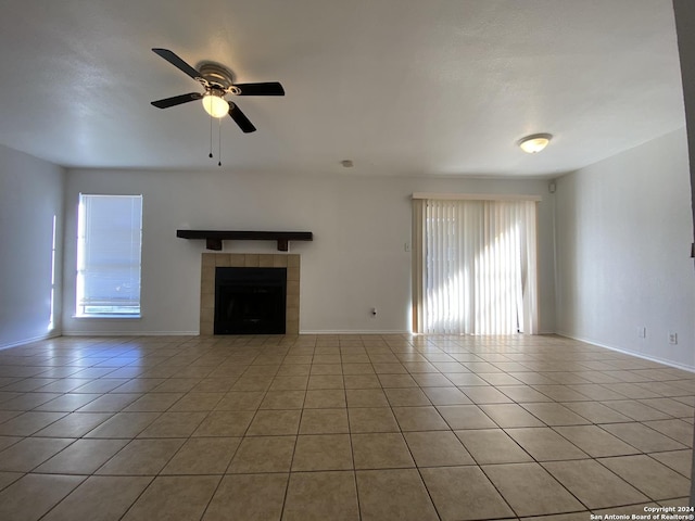 unfurnished living room featuring baseboards, a ceiling fan, light tile patterned flooring, and a fireplace