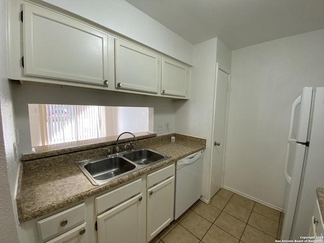 kitchen with white cabinets, light tile patterned floors, white appliances, and sink