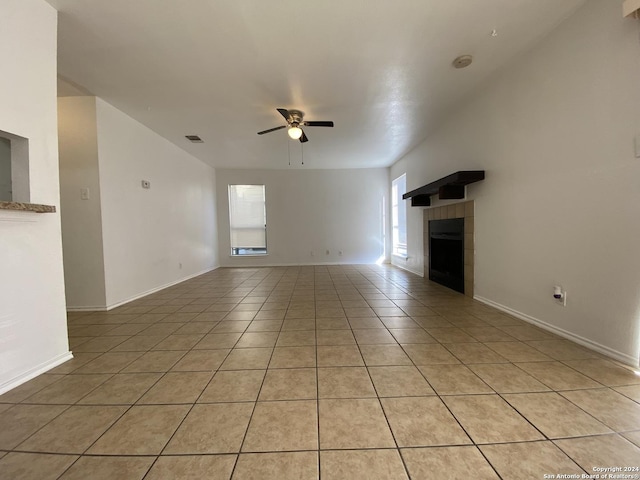 unfurnished living room with a tiled fireplace, ceiling fan, and light tile patterned floors