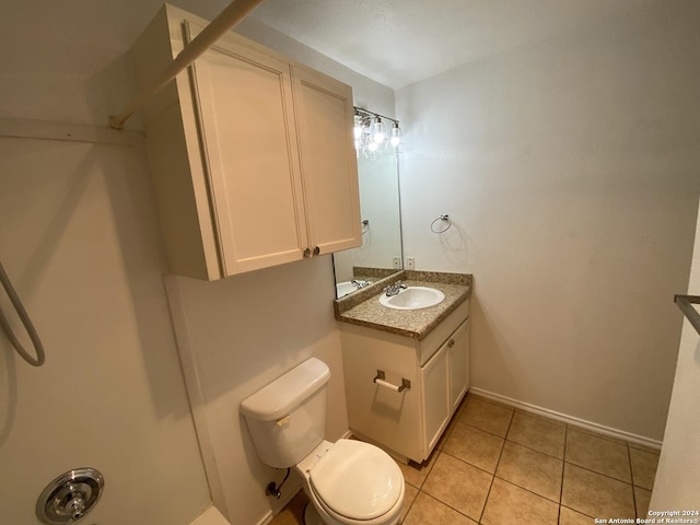 bathroom featuring baseboards, toilet, vanity, and tile patterned flooring