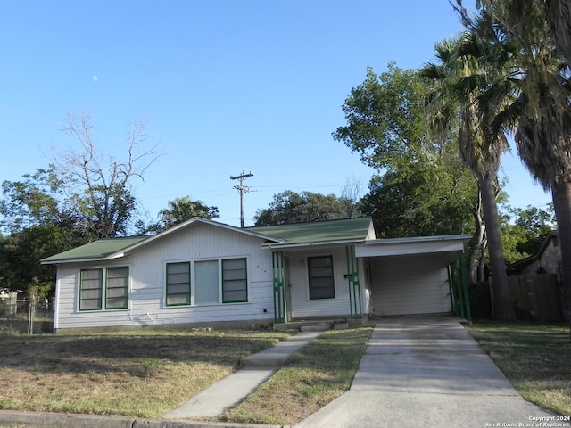 ranch-style home featuring a front lawn and a carport