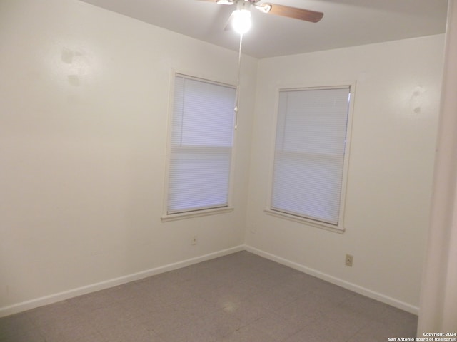 tiled spare room with ceiling fan