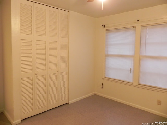 unfurnished bedroom featuring ceiling fan, a closet, and tile patterned flooring