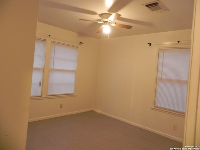 tiled empty room featuring ceiling fan